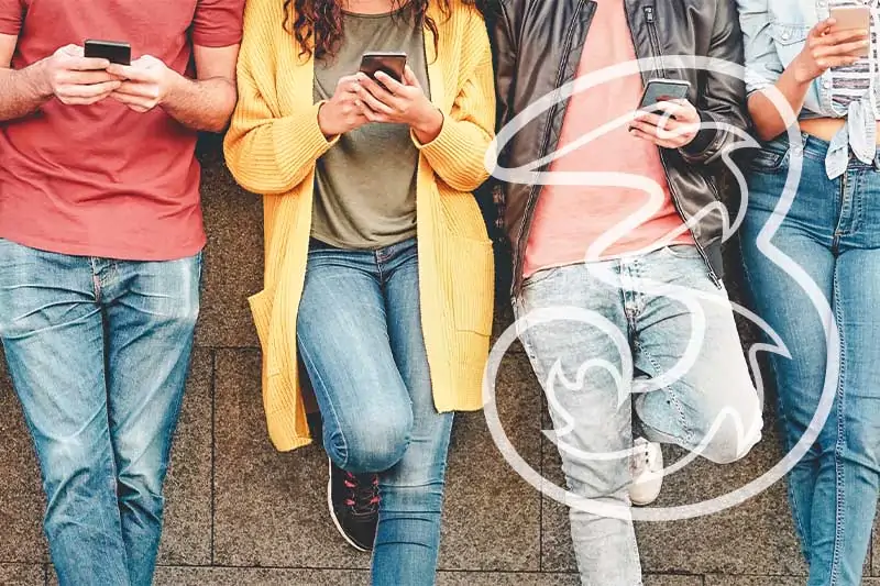 Personen lehnen an eine Wand mit Smartphone in der Hand